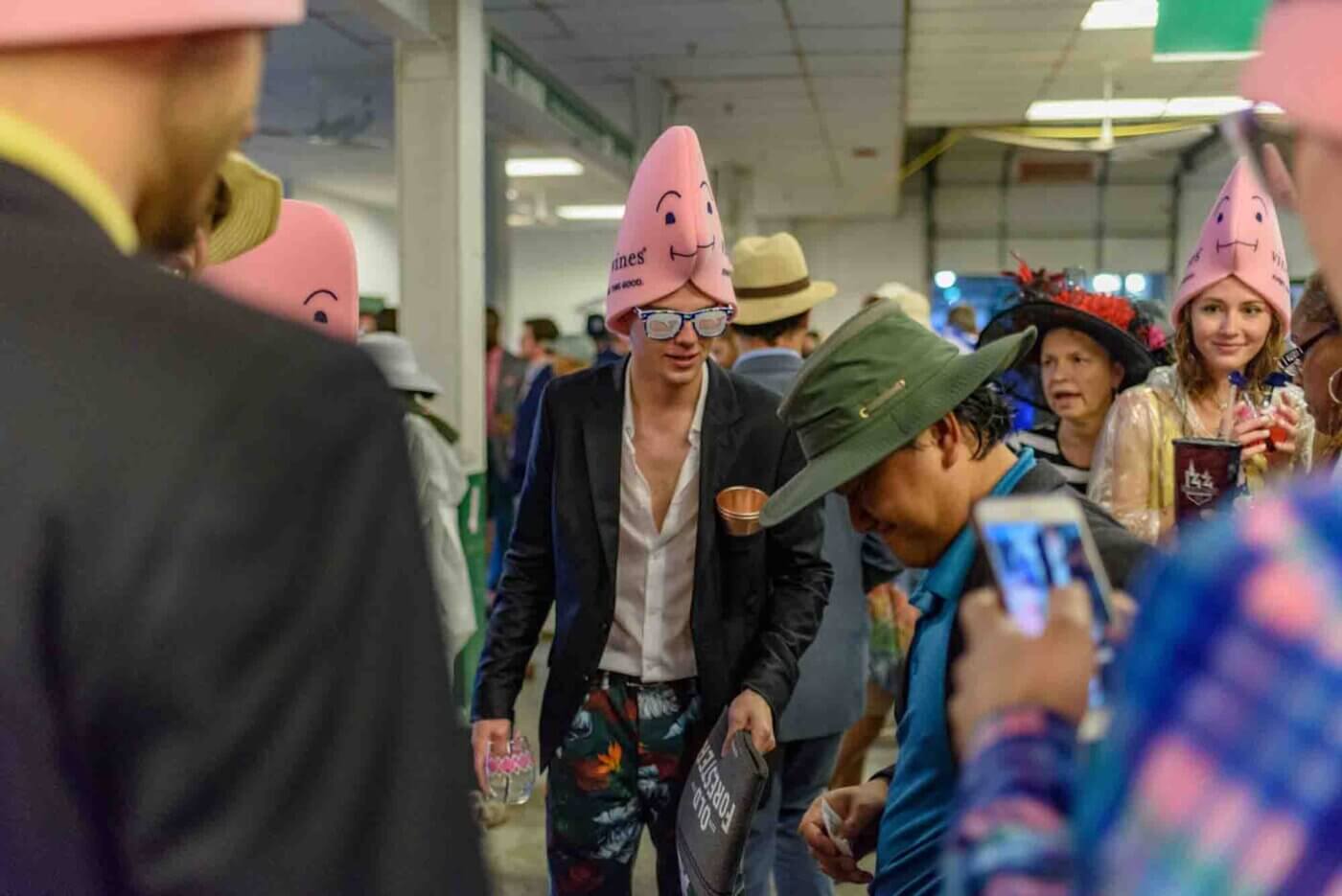 Soggy racing fans take shelter from the rain to make bets on the running of the 144th Kentucky Derby. May 5, 2018
