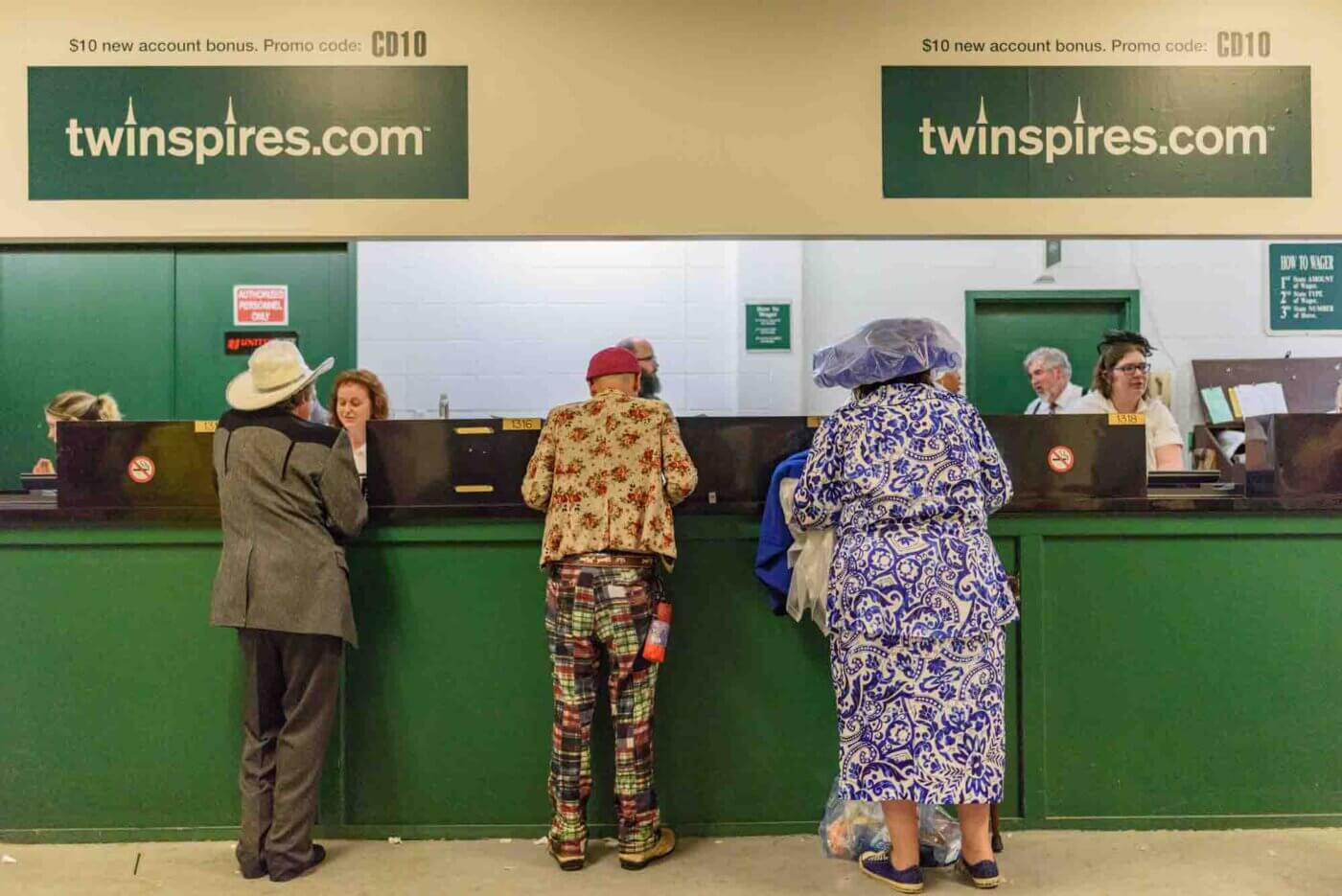 Soggy racing fans take shelter from the rain to make bets on the running of the 144th Kentucky Derby. May 5, 2018