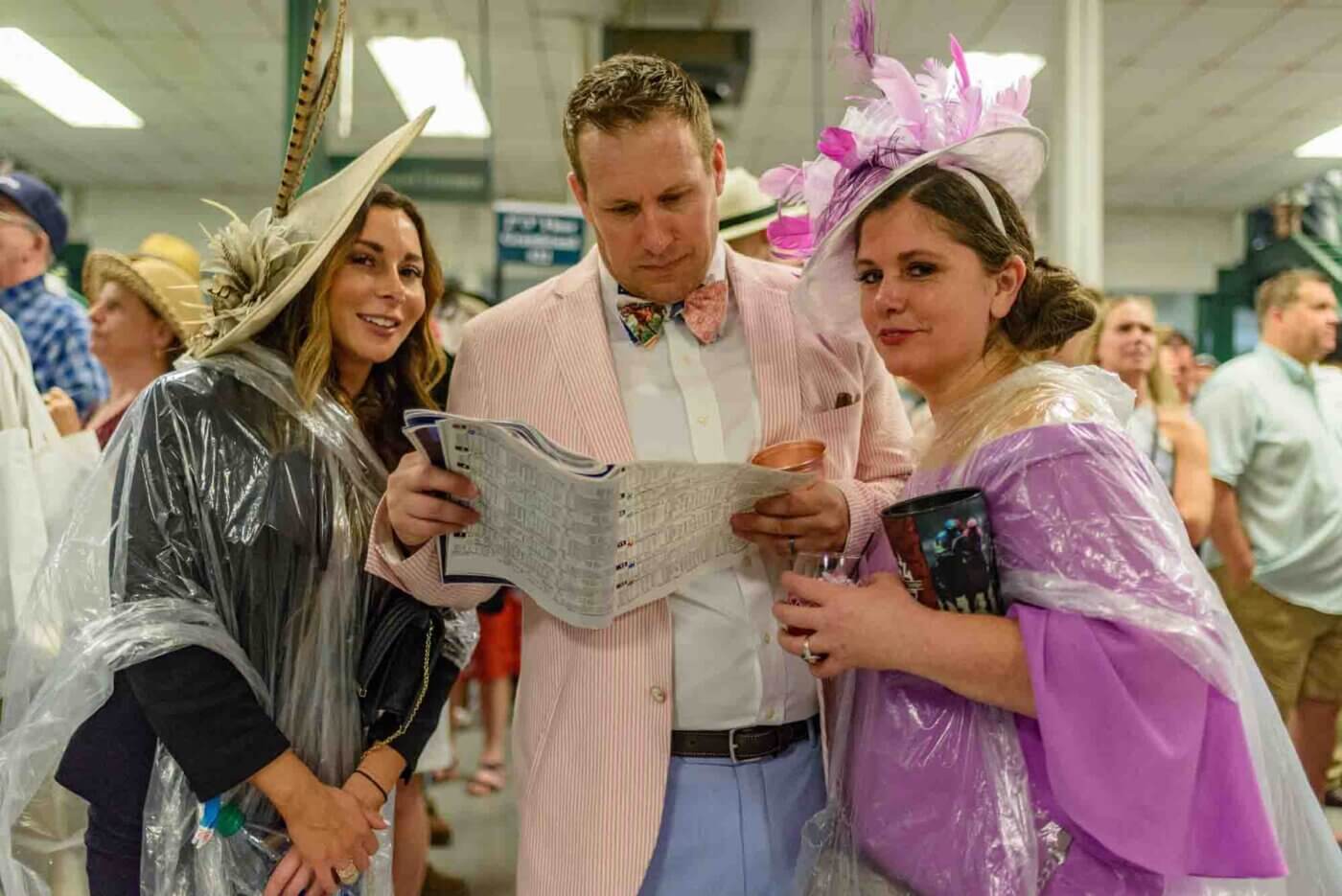 Soggy racing fans take shelter from the rain to make bets on the running of the 144th Kentucky Derby. May 5, 2018