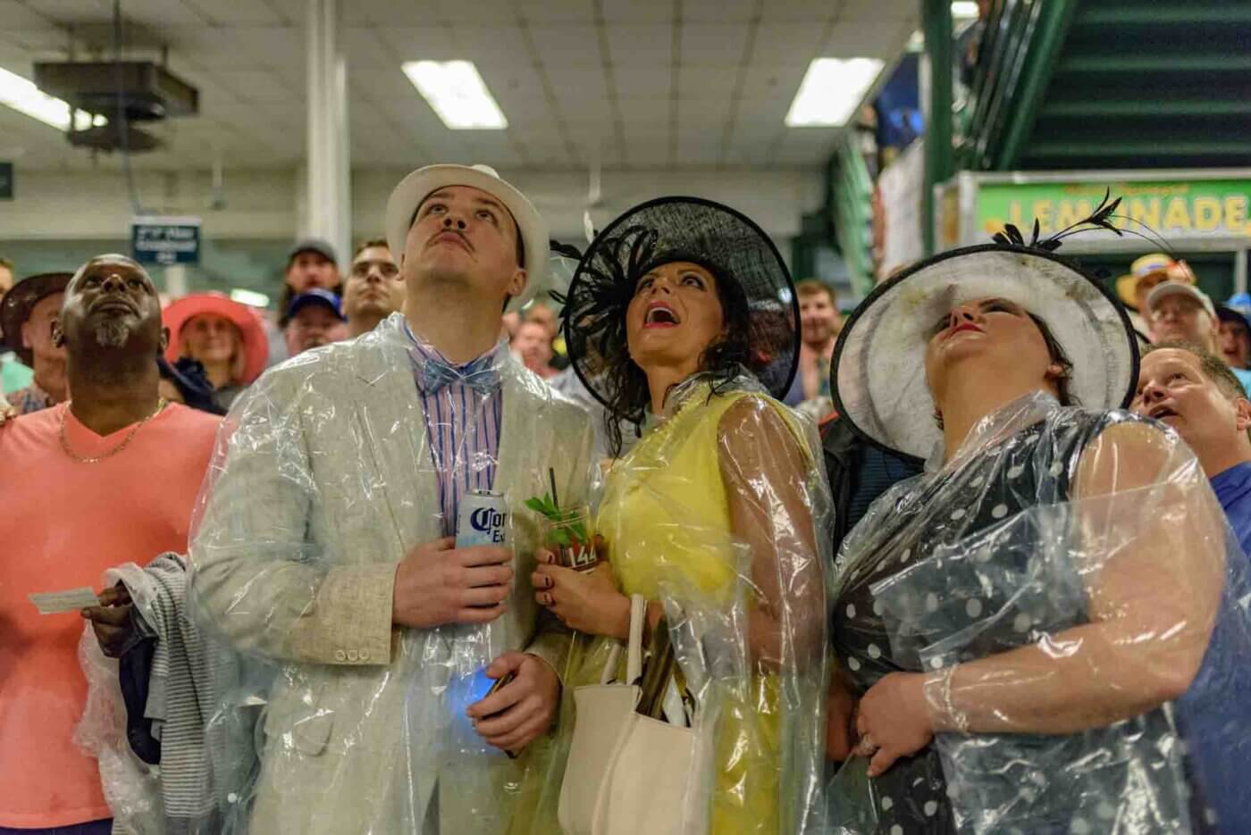 Soggy racing fans take shelter from the rain to make bets on the running of the 144th Kentucky Derby. May 5, 2018