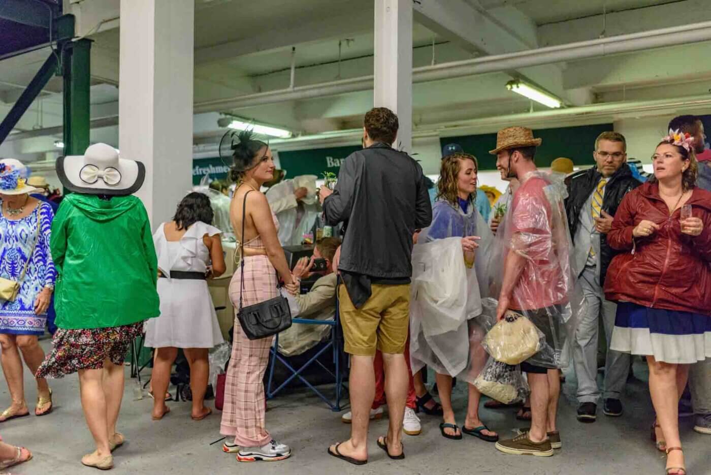 Soggy racing fans take shelter from the rain to make bets on the running of the 144th Kentucky Derby. May 5, 2018