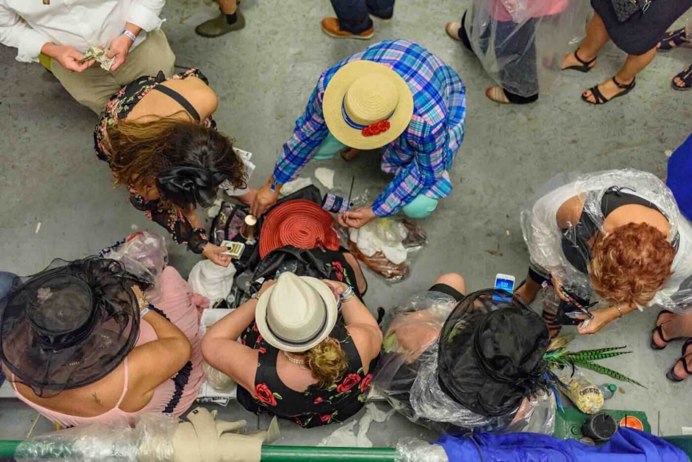 Soggy racing fans take shelter from the rain to make bets on the running of the 144th Kentucky Derby. May 5, 2018