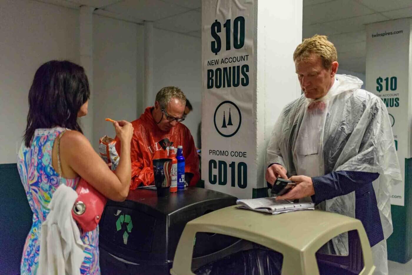 Soggy racing fans take shelter from the rain to make bets on the running of the 144th Kentucky Derby. May 5, 2018