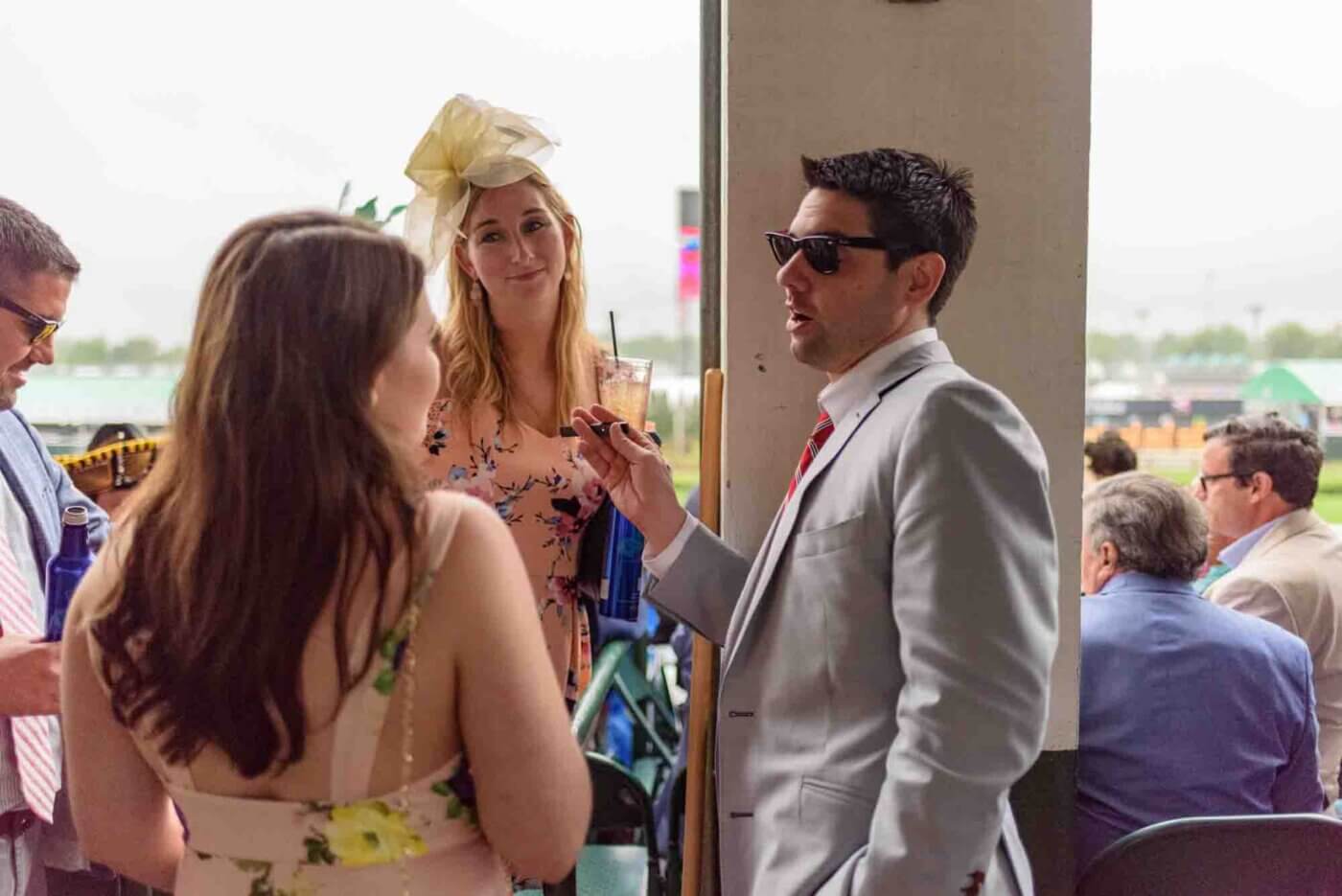 Soggy racing fans take shelter from the rain to make bets on the running of the 144th Kentucky Derby. May 5, 2018
