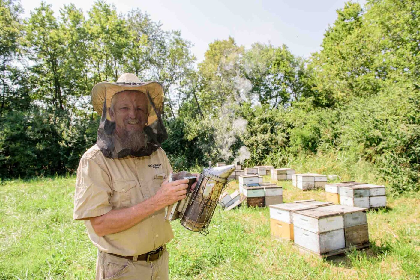 Rick Sutton, owner of Sutton Honey Farms in Lancaster, Ky., visits a bee yard near the radio towers and satellite dishes of the Hometown Radio Network, Tuesday, Sept. 8, 2020 outside Danville, Ky. (Photo by Brian Bohannon)