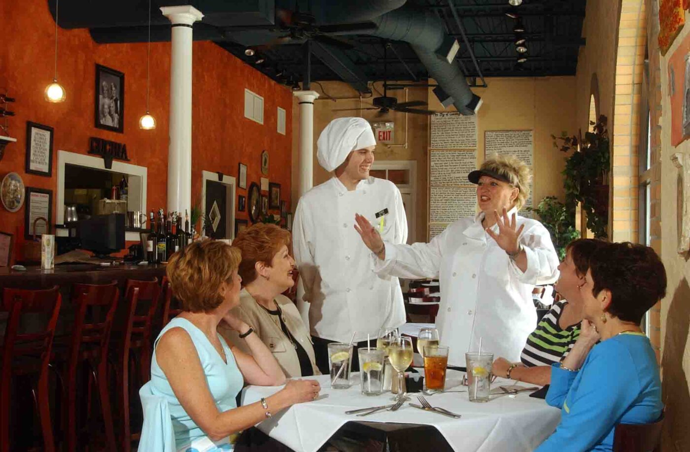 Melillo's at Piazza di Felice: Line Chef Ehren Mayer, center left, and Chef Michele Melillo Clem greet a party of Saturday lunch guests. Guests are, from left, Gail Schank, Mary Rivard, Johanna Campell and Elizabeth Jeffries.