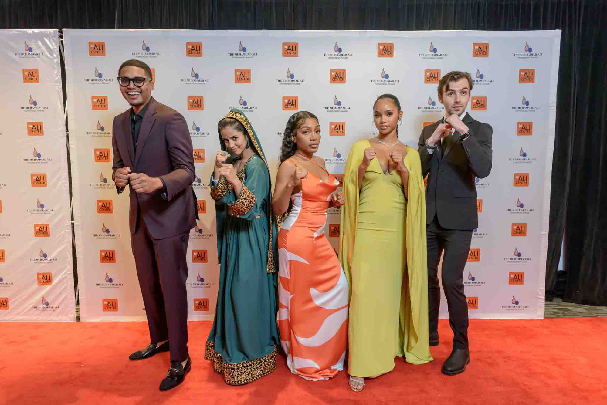 The recipients of four of the six Core Principle Awards, Darius Baxter, left, Sonita Alizada, Chelsea Miller, Nialah Edari and Christian Stephen strike a fighting pose on the red carpet at the eighth annual Muhammad Ali Humanitarian Awards Friday, November 12, 2021, at the Muhammad Ali Center in Louisville, Ky. The two other Core Principle Award winners, Clementine Jacoby and Yvette Ishimwe attended virtually. (Brian Bohannon/AP Images for Muhammad Ali Humanitarian Awards)
